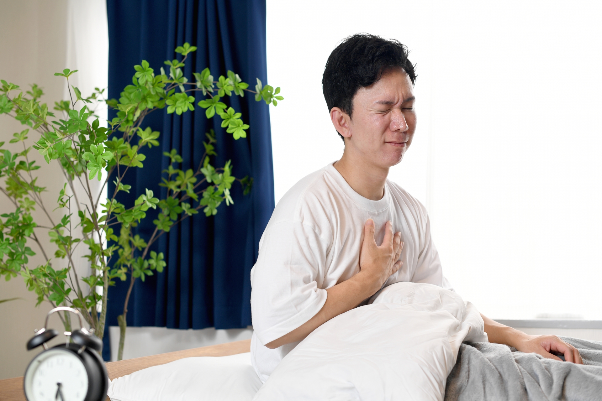 起床時に胸やけに悩む男性