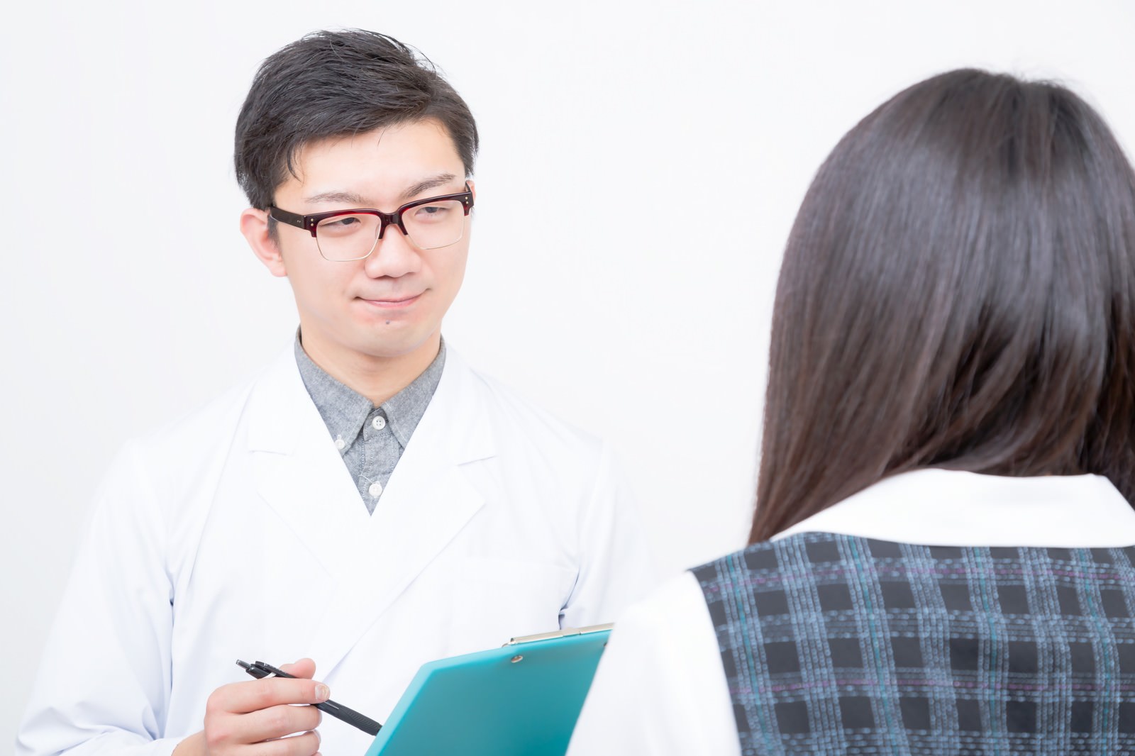 医師が診察室で患者に説明している写真